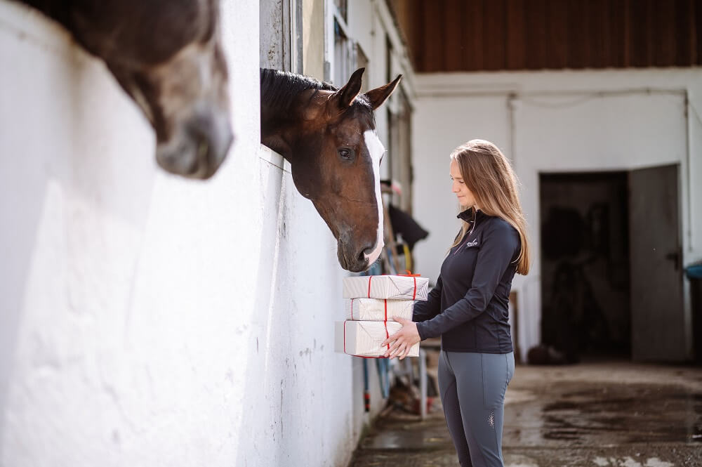 Frau zeigt Pferd Geschenke