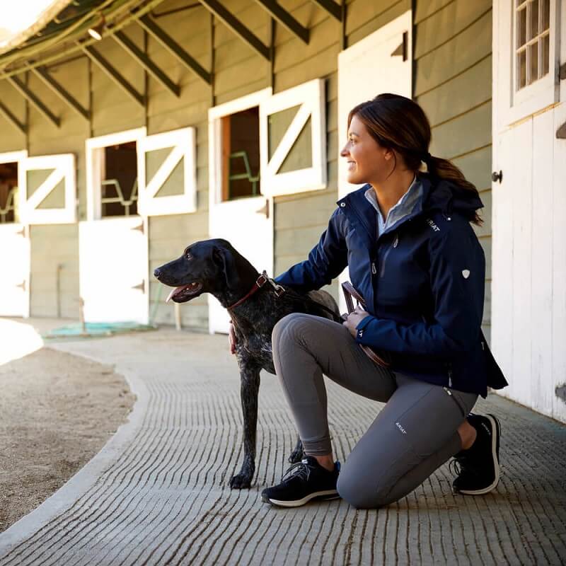 Regenjacke Ariat Frau sitzt neben Hund