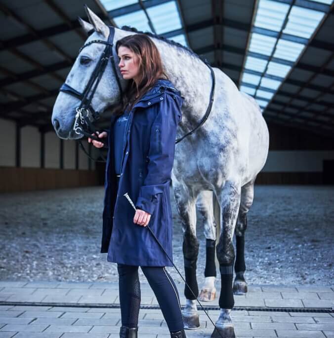 Reitregenmantel Euro Star Frau hält Pferd fest