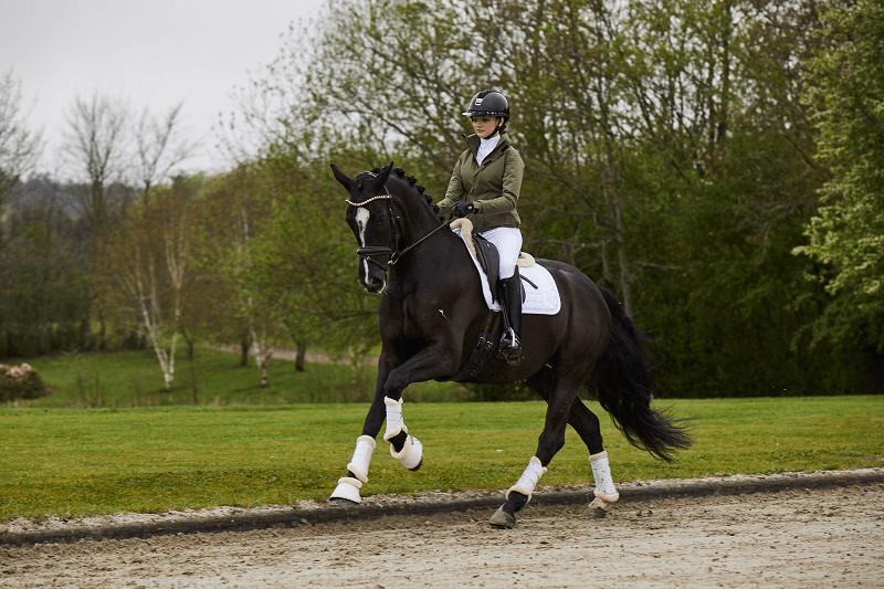 Reiterin galoppiert auf dem Reitplatz