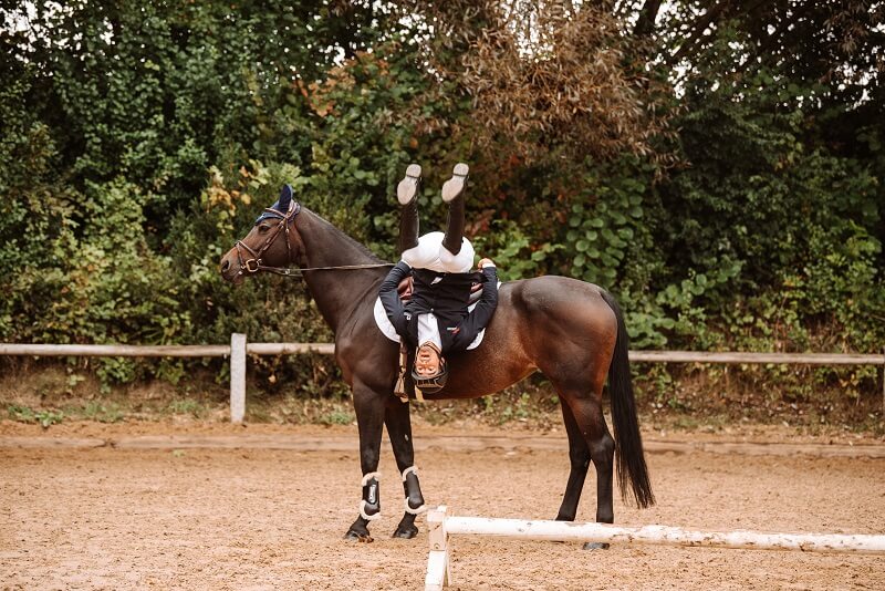 Gymnastik auf dem Pferd Reiter macht Gymnastik auf dem Pferd