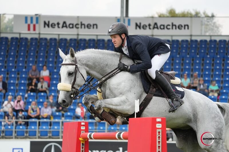 Reiter springt mit Pferd über Hindernis