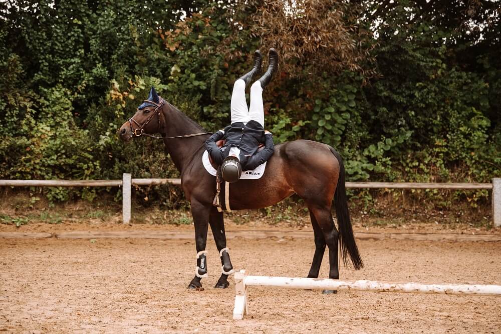 Reiter macht Gymnastik auf Pferd