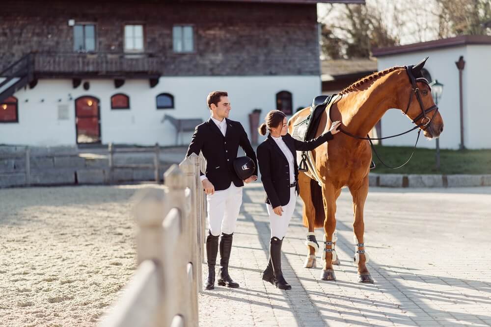 Pärchen in Turnierkleidung mit Pferd