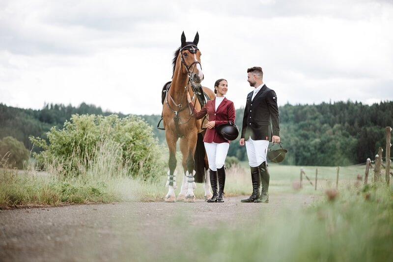 Frau und Mann im Turnieroutfit mit Pferd