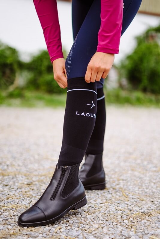 Geschenk-Reitsocken Reiterin zieht Reitsocken hoch