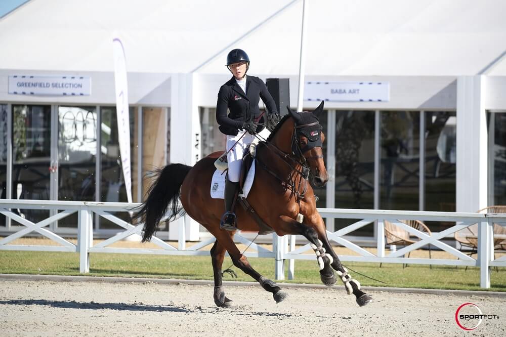 Reiterin galoppiert mit Pferd am Turnier